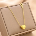 Gold titanium steel heart necklace with key pendant on beige jewelry display box - Gold