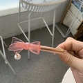 Detailed shot of pink acetate bow hair clip with gold metal base and hanging pearl charm - Water Pink Bow
