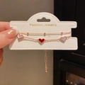 Double-layered rose gold bracelet featuring red and white heart charms on a display card - Rose Gold