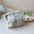 Close-up of green floral quilted cotton makeup bag with Simple Wish brand label - Green Vine Floral