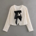 Close-up of a white sequin cropped jacket featuring two large black decorative bows - S / Tops / Off White