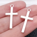 Silver cross pendants for DIY jewelry making shown held on a hand for scale and detail - 27x13mm (1.1g)