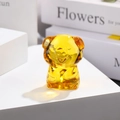Macro shot of a yellow glass pig figurine on a white surface with decorative books - Zodiac Pig / Gold Yellow