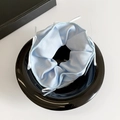 Light blue satin scrunchie with delicate white ribbon bows in a sleek black bowl - Light Blue