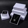 Macro detail of white linen textured jewelry gift box with black sponge lining - Textured Ice White