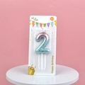 Blue and pink gradient birthday candle number 2 with gold glitter on a pink background - Number 2 / Pink and Green Gradient