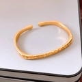 Dettaglio di un bracciale aperto placcato oro con carattere Fu a rilievo e scritte buddiste - Placcato Oro Vero Oro