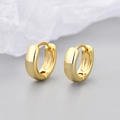 Polished gold huggie hoop earrings on a textured paper surface in a macro detail shot - Polished Smooth Style / Medium / Gold