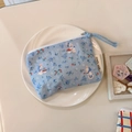 Close-up of small blue floral cotton coin purse with cute rabbit patterns on a white plate - Blue Base Little Rabbit