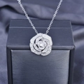 Makroaufnahme der silbernen Rosenkette mit Pavé-Diamanten auf dunkler Seide - Anhänger Mit Kette