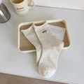 Naturweiße Baumwollsocken mit bunten Punkten und grüner Good-Stickerei an der Seite - GOOD Buchstabe