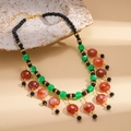 Bohemian beaded tassel necklace with colorful resin beads and gold accents on ceramic plate - Colorful