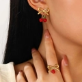 Gold stainless steel jewelry set with bow and red cherry charms on model - Red Bead Earrings & Ring Set