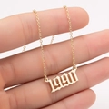 Macro shot of gold-plated 1990 year pendant in gothic font with fine link chain - 1990 / Gold
