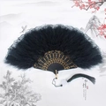 Detail of black feather folding fan with gold floral carving and elegant lace edges - Lace Black Feather Fan