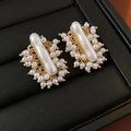 Close-up of gold irregular geometric pearl earrings in a luxury black jewelry box - Gold