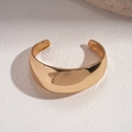 Dettaglio di un ampio bracciale rigido a cupola placcato oro 18k su pietra bianca - Bracciale in Metallo Lucido / Oro