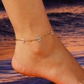 Golden flower anklet with pink and blue beaded blossoms on model's ankle by the sea - 002 Flower / Anklet