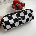 Detail of hand holding checkerboard canvas pencil case with a black woven logo tag - Black Checkerboard (Small)