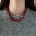 Close-up of red beaded necklace worn over a grey sweater for a vintage French aesthetic - 11mm / Red