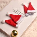 Quattro mini cappelli di Natale rossi e bianchi con pompon su sfondo bianco festivo - Berretto con pompon rosso / Cappello di Natale 4*7CM