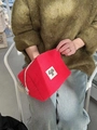 Trousse à cosmétiques rouge matelassée avec écusson chat, tenue à la main par l'usager - Rouge