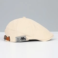 Detail of beige canvas beret featuring a brown leather buckle and embroidered side label - Beige