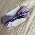 Detail view of the lavender satin ribbon bow hair clip with black crocodile base - Purple