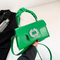 Green crossbody bag with pleated handle and rhinestone buckle on a textured synthetic leather - Green