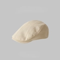 Classic beige cotton linen newsboy cap with fine fabric texture in a minimalist studio shot - Beige Solid