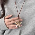 Dettaglio della collana con ciondolo a stella marina, cordino marrone e perla in legno - 22# Cordino in Pelle Marrone Ciondolo Stella Marina e Perla in Legno (HN7339)