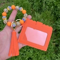 Detail of orange silicone bead wristlet with leopard print beads and tassel card holder - Orange