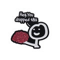 Black enamel pin featuring a stick figure holding a red brain with a witty message bubble - Hey You Dropped Brain (xz9934)