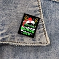 Weihnachts-Krankenschwester-Anstecknadel an einem Jeansjackenkragen in Nahaufnahme - XC1083-Weihnachtsschwester-Crew