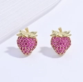 Macro detail of gold-plated strawberry stud earrings set with pink crystals on white silk - Gold Rose Red Stone Strawberry Style (VE1576)
