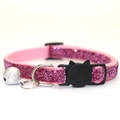Pink glitter nylon cat collar with silver bell and black cat face buckle on white background - Pink