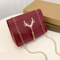 Deep red quilted square crossbody bag featuring a golden deer head and metal tassels - Red