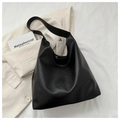 Primer plano del bolso hobo negro de cuero PU con texturas naturales sobre un blazer blanco - Negro