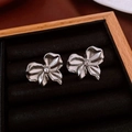 Detailed close-up of silver floral earrings with zircons in a black velvet jewelry box - Abstract Flower Bowknot Stud Earrings