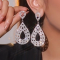 Boucles d'oreilles pendantes gouttes argentées avec strass sur un mannequin - Goutte d'Eau Creuse Argentée