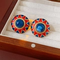 Gros plan de boucles d'oreilles vintage en émail rouge et bleu dans une boîte à bijoux beige - Base Or Émail Rouge Bleu (Tige Argent)