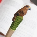Handcarved wooden bird pen featuring intricate brown feathers and a green carved base - Brown Eagle