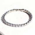 Detailed view of silver square-cut zircon tennis bracelet with 5mm stones on white stone - White Zirconia
