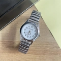 Detailed macro of a silver elastic quartz watch with white dial on a wooden background - Women's Watch / Silver White Dial