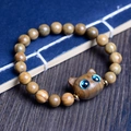 Handcrafted ebony cat bead bracelet with blue cat-eye detail on vintage wooden background - Green Sandalwood 8mm*20pcs + Green Cat Head