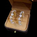 Orecchini a cerchio dorati a forma di C con cristalli quadrati su velluto marrone - Quadrato Bianco Oro (Perno in Argento)