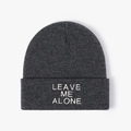 Close-up of LEAVE ME ALONE embroidery on thick dark grey knitted beanie hat - One Size / Dark Gray