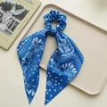 Detail van donkerblauwe paisley haarelastiek met lang lint op een elegant dienblad - Blauw Paisley Lint