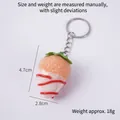 Artificial strawberry keychain featuring white chocolate coating and jam sauce details - White Jam - Orange Strawberry (Keychain)