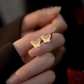 Primer plano macro de pendientes de mariposa dorados con acabado metálico texturizado - Estilo de Mariposa Dorada (2# Aguja de Plata - Oro)